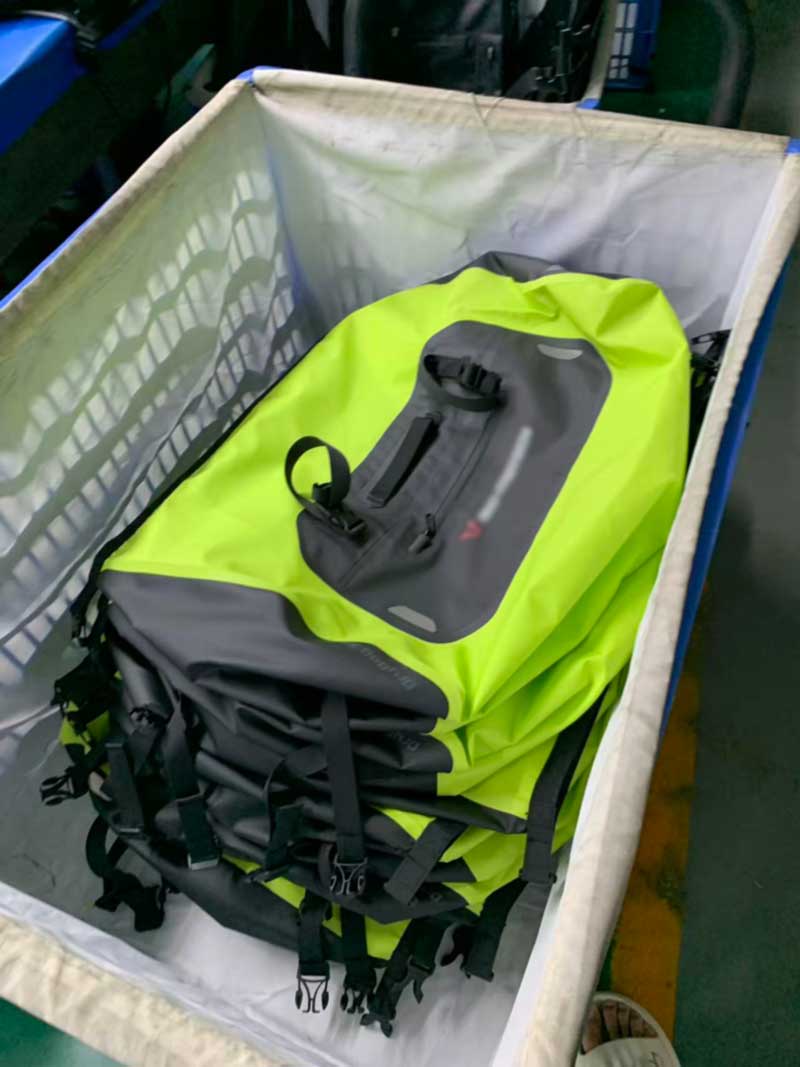 Finished waterproof motorcycle bags stacked in a lined trolley ready for packing